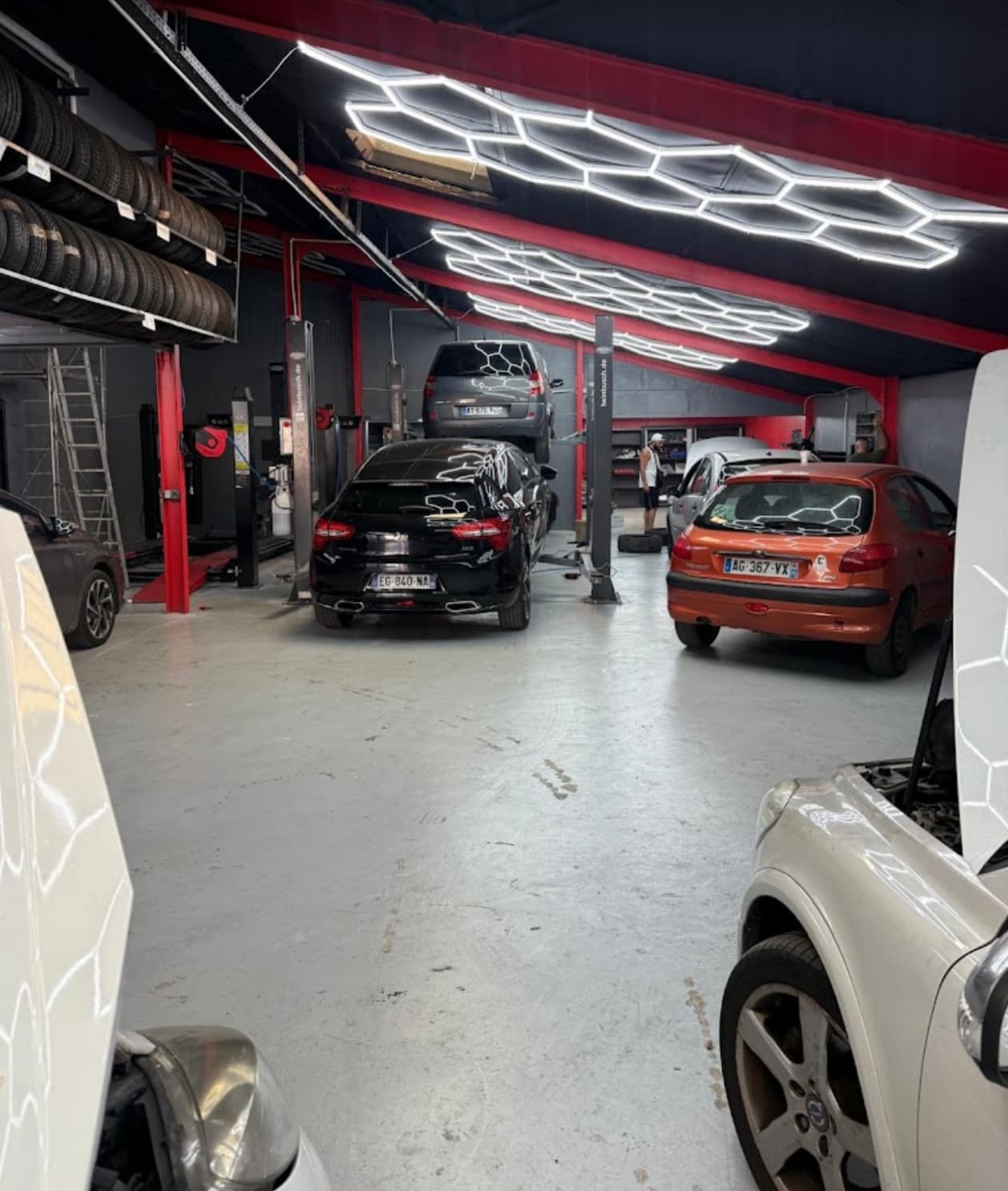 Atelier du garage avec ponts élévateurs et véhicules en réparation